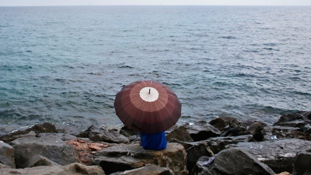 A migrant sits on the beach at the Franco-Italian border in Ventimiglia, Italy.