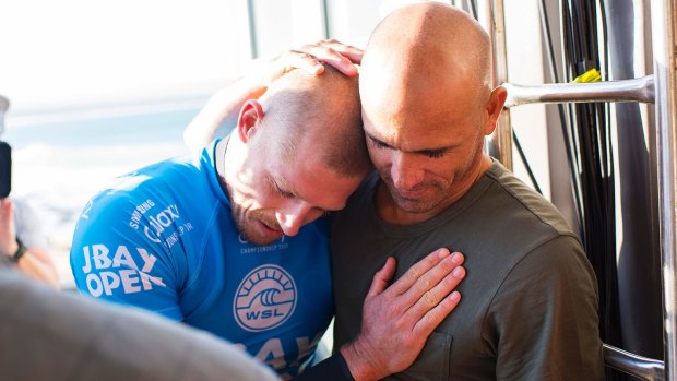 Mick Fanning of Australia (pictured blue) is hugged by Kelly Slater (US) after being attacked by a shark during the final of the JBay Open on Sunday.
