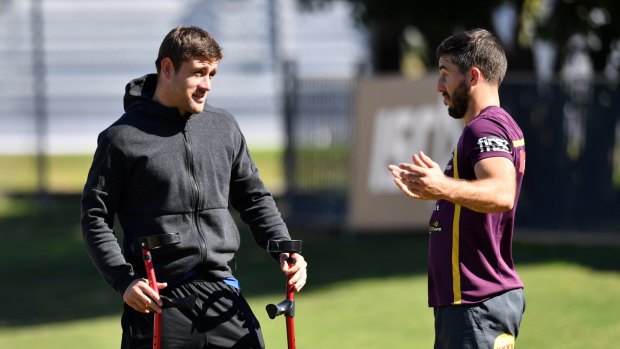 Big shoes: Injured Broncos hooker Andrew McCullough chats with Ben Hunt during Monday's training session in Brisbane.
