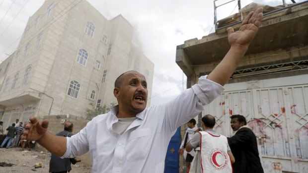 Red Crescent workers and civilians in the streets after an air strike in the Yemeni capital.