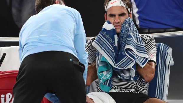 Roger Federer receives treatment from trainer during his men's singles final against Rafa Nadal.