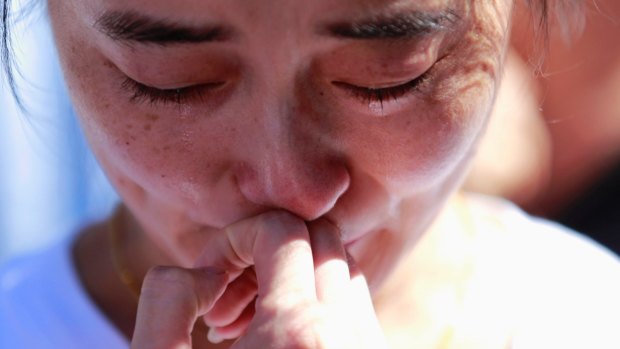 A family member of a passenger onboard the MH370 cries at a temple in Beijing in September, 2014. 