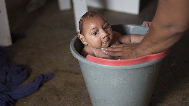 Solange Ferreira bathes her son Jose Wesley in a bucket at their house in Poco Fundo, Pernambuco, Brazil. Ferreira says her son enjoys being in the water, she places him in the bucket several times a day to calm him.
