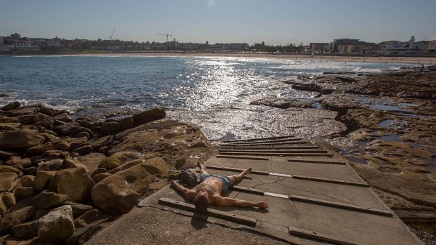 A bather at Ben Buckler's in North Bondi enjoys the early spring sun after work.