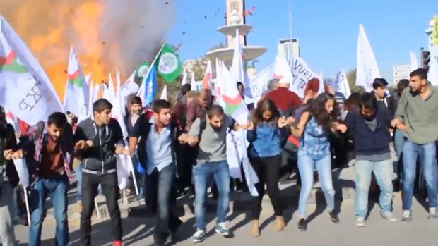 Participants in the peace rally react at the moment of the first explosion on Saturday.