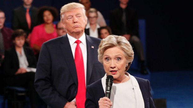 Donald Trump "towered behind" Hillary Clinton as she answered some questions during the second debate.