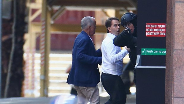 Two hostages run to safety outside the Lindt cafe.