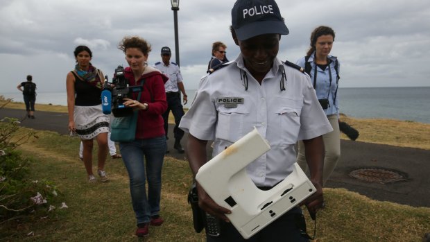 National Police Brigadier Gisele Cadar carries the plastic beach debris away from St Denis beach, Reunion Island on Tuesday.