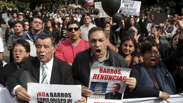 Politician Fidel Espinoza, right, and fellow Chileans protest as Bishop Juan Barros conducts his first service as bishop in Osorno cathedral, south of Santiago.