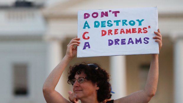 Woman holds up a sign during a rally supporting Deferred Action for Childhood Arrivals, or DACA, outside the White House.