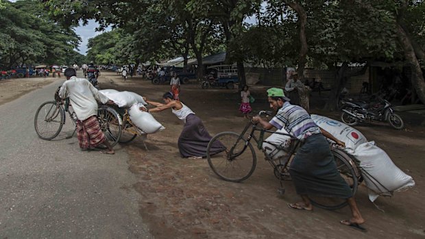 Rohingya men prepare to deliver rice donations from the World Food Program in Sittwe in May.