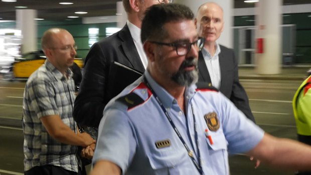 A Cadman family member  is escorted to a car after landing in Barcelona.

