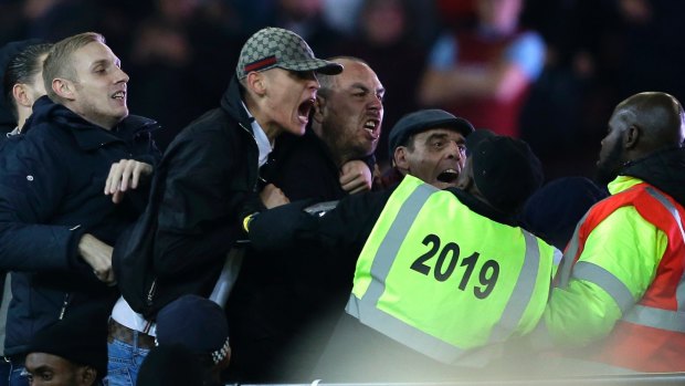Supporters and stewards clash during the English League Cup soccer match between West Ham United and Chelsea at the London stadium on Wednesday.