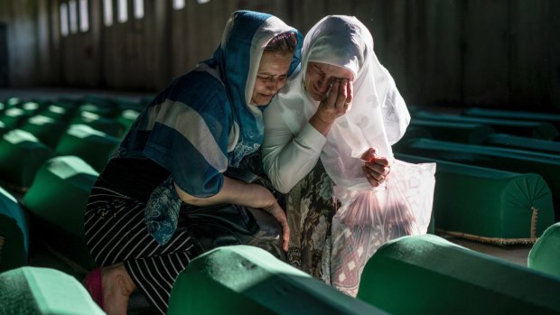 Relatives of people killed in the Srebrenica massacre mourn over their loved ones' coffins before burial in Potocari, Bosnia.