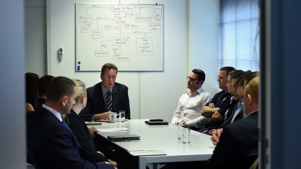 Andrew Donoghoe briefs members of his AFP team inside the Australian embassy in The Hague.