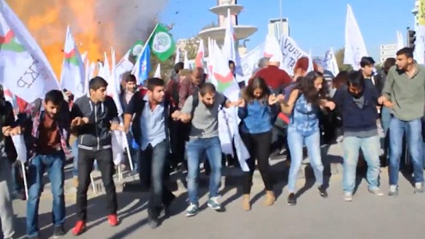 Participants in the peace rally react at the moment of the first explosion on Saturday.