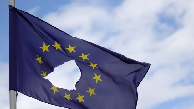 A European Union flag, with a hole cut in the middle, flies at half-mast outside a home in Cheshire, Britain. 