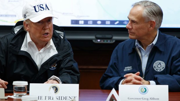 Republican Texas Governor Greg Abbott listens as President Donald Trump speaks about Harvey relief efforts in Austin, Texas. 