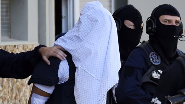French police escort Yassin Salhi from his flat in Saint-Priest on Saturday after he confessed to the grisly beheading.