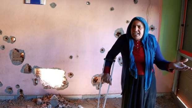 A woman inside her bullet-ridden house in Nusaybin, Turkey. Civilians in south-east Turkey have been caught in the middle as government forces and Kurdish militants fight for control over urban areas.