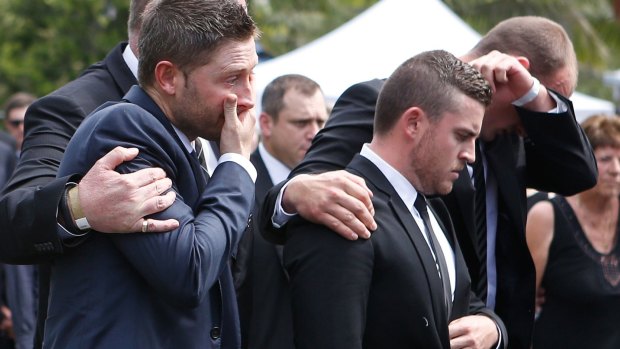 United in grief: Michael Clarke is comforted as he arrives at Phillip Hughes’ funeral on Wednesday.