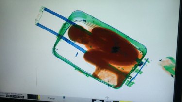 An X-ray image shows an 8-year-old boy hidden in a suitcase, in May 2015.