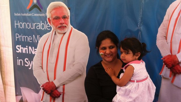 Members of the Indian community pose with a cutout of Narendra Modi at Homebush on Monday.