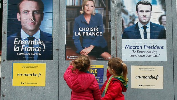 Children walk past election campaign posters in south-west France early last month.