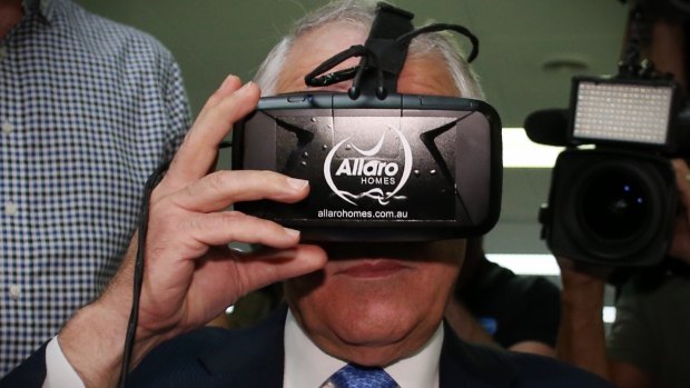 Prime Minister Malcolm Turnbull looks at real estate through virtual reality goggles.