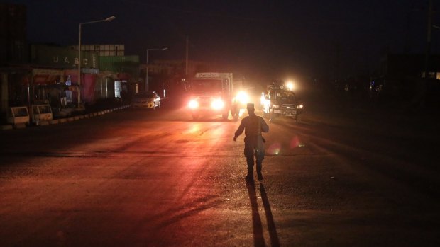 Afghan police block a road leading to the site of the explosion in Kabul.