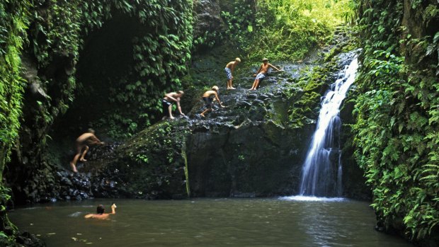 Hikers enjoy a cool dip in the waterfalls and pool at the end of Maunawili Falls Trail.
