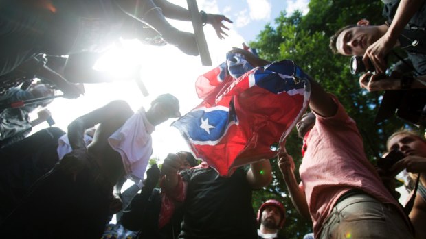 Counter-protesters tear a Confederate flag during the white nationalist rally, on Saturday. 
