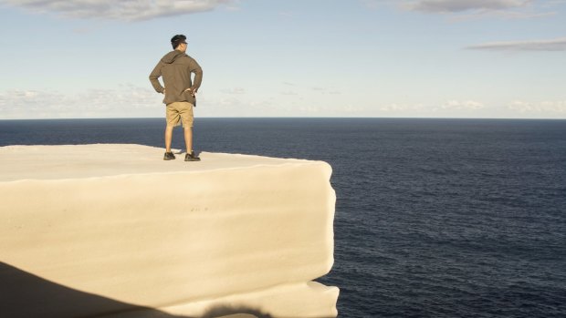 A man stands on Wedding Cake Rock.