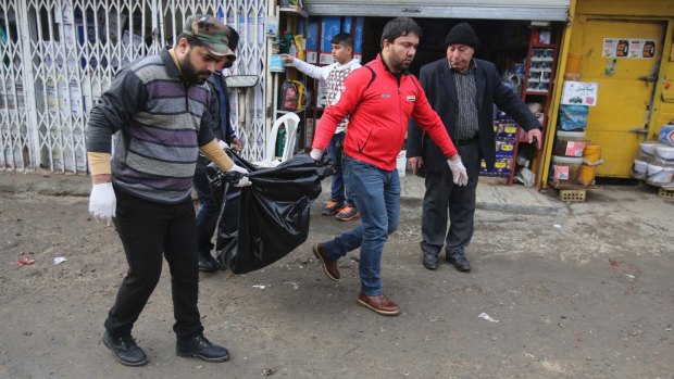 Men carry the body of a person killed in the blast in Baghdad.
