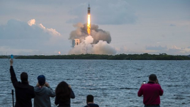 Spectators cheer on the launch of NASA's Orion spacecraft. 