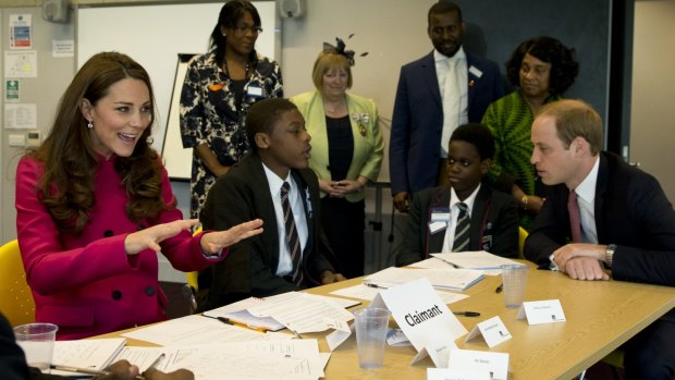 The Duchess of Cambridge talks to students who are taking part in a role playing lesson about the workings of a British court at the Stephen Lawrence Centre in London. 