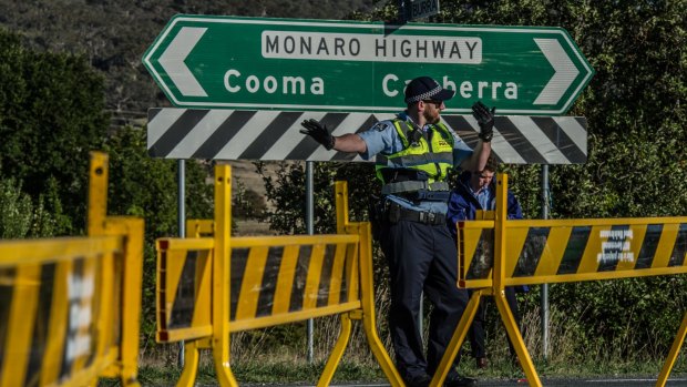 ACT Police conduct road traffic management near the scene of the fatal accident involving a cyclist and a car on the Monaro Highway.