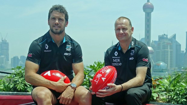 Port Adelaide captain Travis Boak and head coach Ken Hinkley in front of the Pudong skyline in Shanghai.