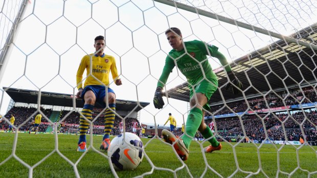 Unlucky break: Wojciech Szczesny collects the ball from the back of the net against Stoke.