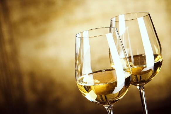 Two glasses of white wine standing side by side.