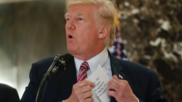 President Donald Trump reaching into his suit jacket to read a quote he made on Saturday.