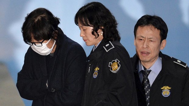 Choi Soon-sil,  left, is escorted onto a bus  as she left the Seoul Central District Court on November 3.