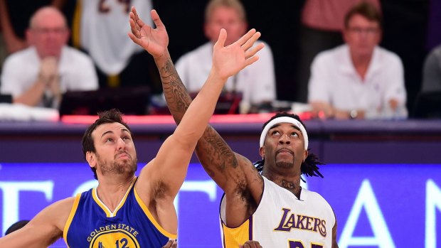Up they go: Warriors centre Andrew Bogut and Lakers counterpart Jordan Hill vie for the opening tip-off.