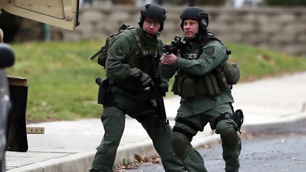 Police move near the scene of one of the shootings.