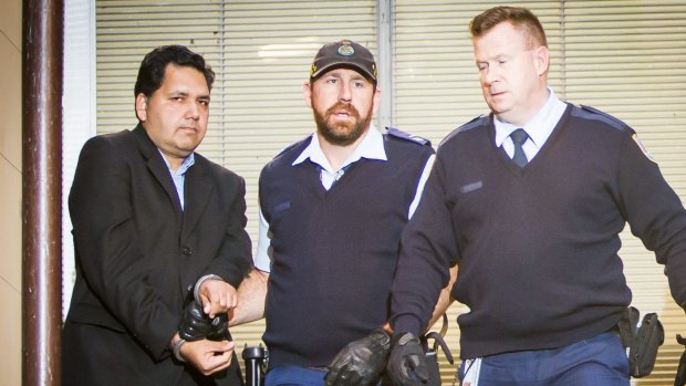 Adeel Khan is led into a police van outside the NSW Supreme Court