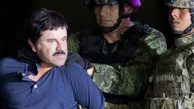 Joaquin "El Chapo" Guzman is made to face the press as he is escorted to a helicopter in handcuffs by Mexican soldiers.