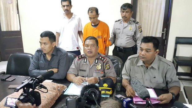 Bali massage therapist Abdurahman (wearing orange) is paraded before the media after being charged with sexually assaulting a 12-year-old boy from Perth.