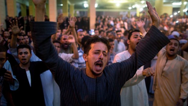 Coptic Christians shout slogans during a funeral service for victims of a bus attack, at Abu Garnous Cathedral in Minya, Egypt.