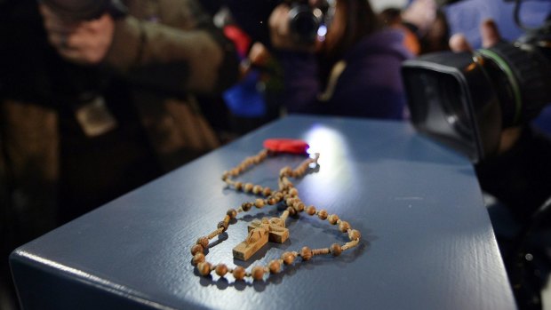 Rosary beads and a poppy are shown at a news conference in Toronto, Ontario.