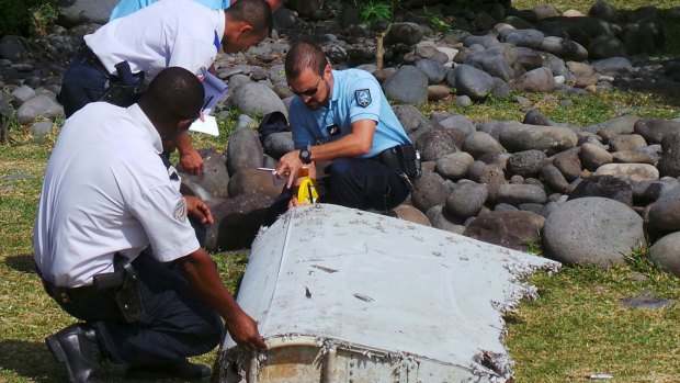 French police inspect the flaperon, now confirmed to be from MH370, on Reunion Island.